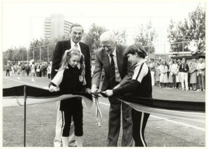 Wethouder Piet Sikma knipt het lint door tijdens de officiële opening van het nieuwe softbalveld. Op de foto v.l.n.r. Wendy Schavemaker, Joop Bakker, Piet Sikma en Evelyn van Dongen. NL-HlmNHA 54016563