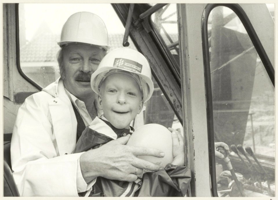 Wethouder Ab van Schooten en een jongetje in een hoogwerker i.v.m. de bouw van tien woningwetwoningen in de Pieterstraat. NL-HlmNHA 54013185 1