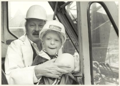 Wethouder Ab van Schooten en een jongetje in een hoogwerker i.v.m. de bouw van tien woningwetwoningen in de Pieterstraat. NL-HlmNHA 54013185 1