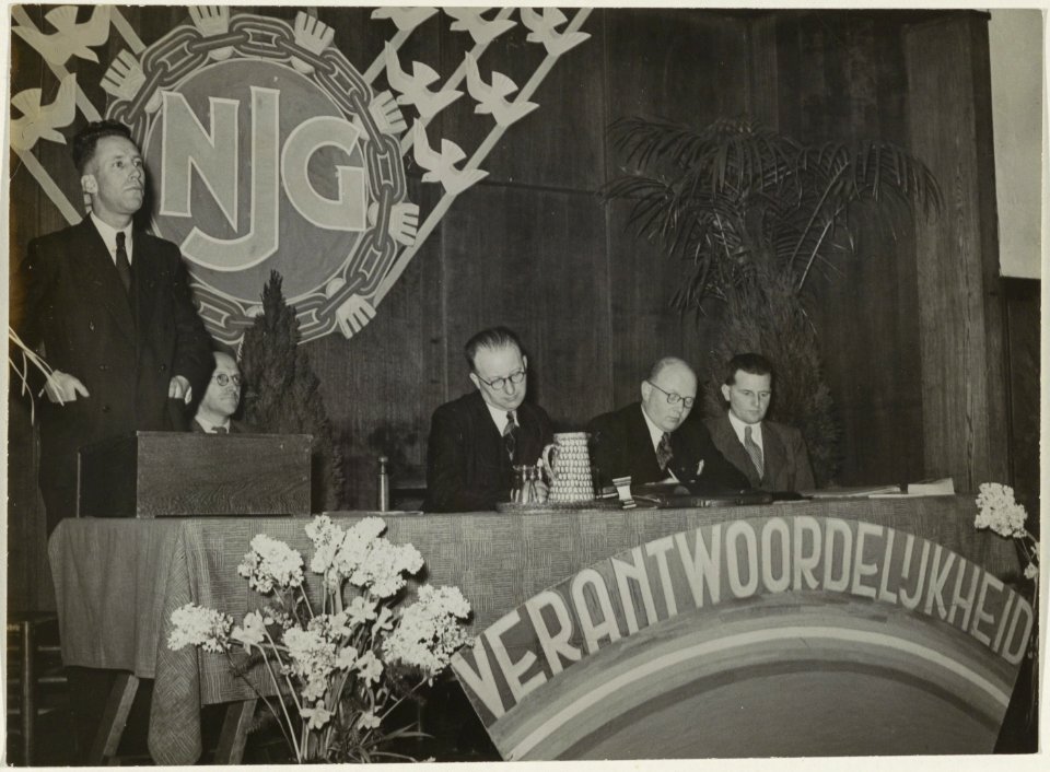 Wethouder D.J.A. Geluk spreekt tijdens het congres van de Nederlandse Jeugd Gemeenschap in het gebouw van de Vereniging van Vrijzinnig Hervormden in de Jacob, NL-HlmNHA 54005491