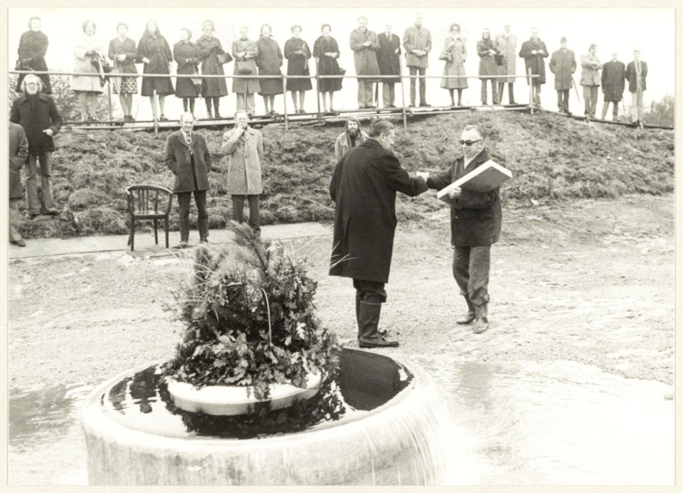 Wethouder A. Thuis, voorzitter van de belangengemeenschap Duinwatervoorziening Zuid Kennemerland, verricht de opening door het eerste Rijnwater in het Nationaal Park De Kennemerduinen te l, NL-HlmNHA 54009627