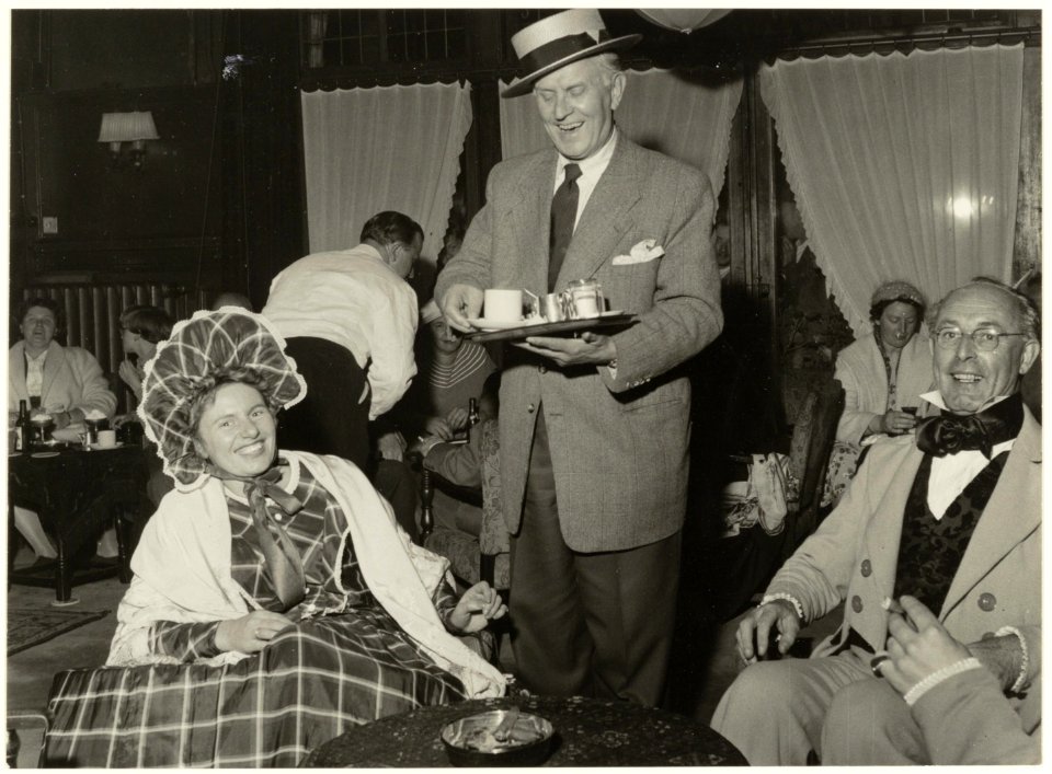 Zanger-varieté artiest Lou Bandy serveert leden van de koffieclub in Hotel Lion d'Or. NL-HlmNHA 54005164