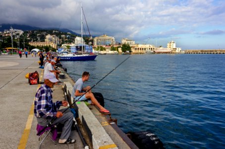 Yalta. Fishermen on city embankment photo