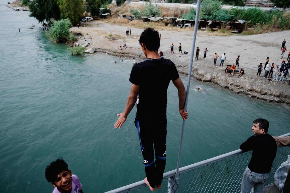 Young men gathered at Mosul's "Old Bridge" over the Tigris River in summer of 2019 to jump into the water and escape summer heat 10