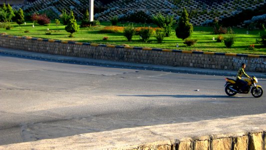Young motorcyclist - yellow - looking to photographer - Nishapur