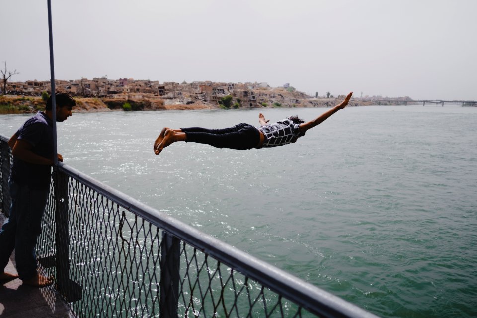 Young men gathered at Mosul's "Old Bridge" over the Tigris River in summer of 2019 to jump into the water and escape summer heat 21