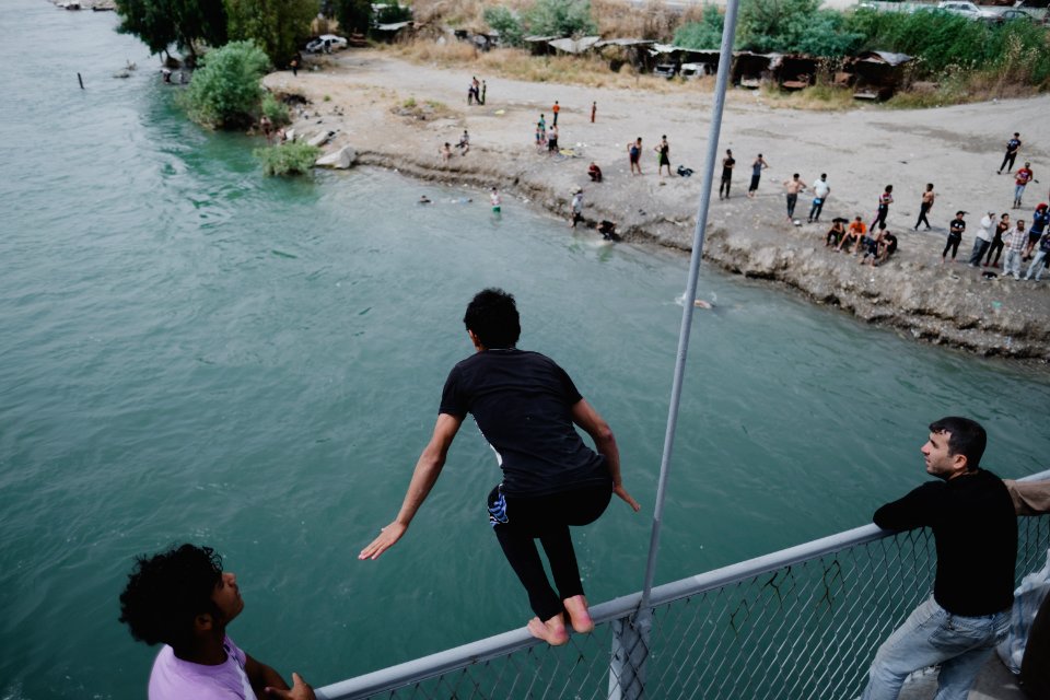 Young men gathered at Mosul's "Old Bridge" over the Tigris River in summer of 2019 to jump into the water and escape summer heat 11
