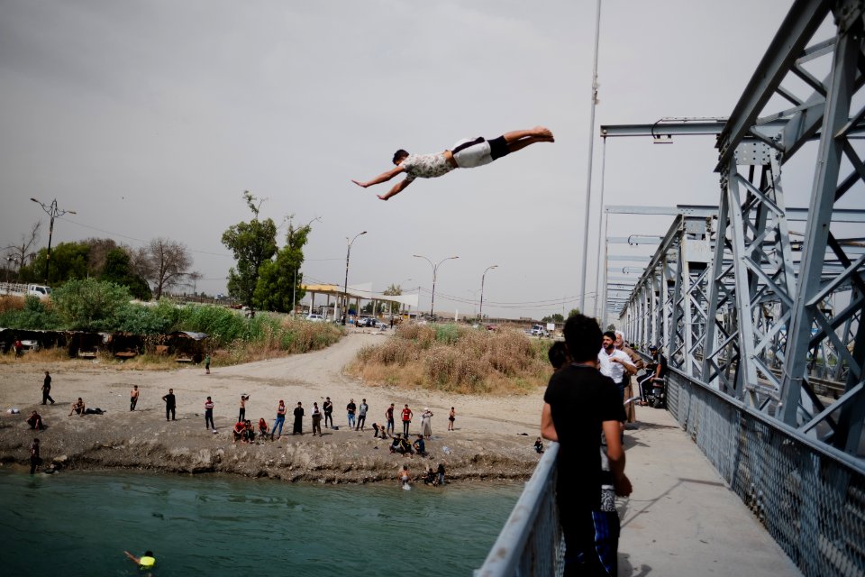 Young men gathered at Mosul's "Old Bridge" over the Tigris River in summer of 2019 to jump into the water and escape summer heat 19