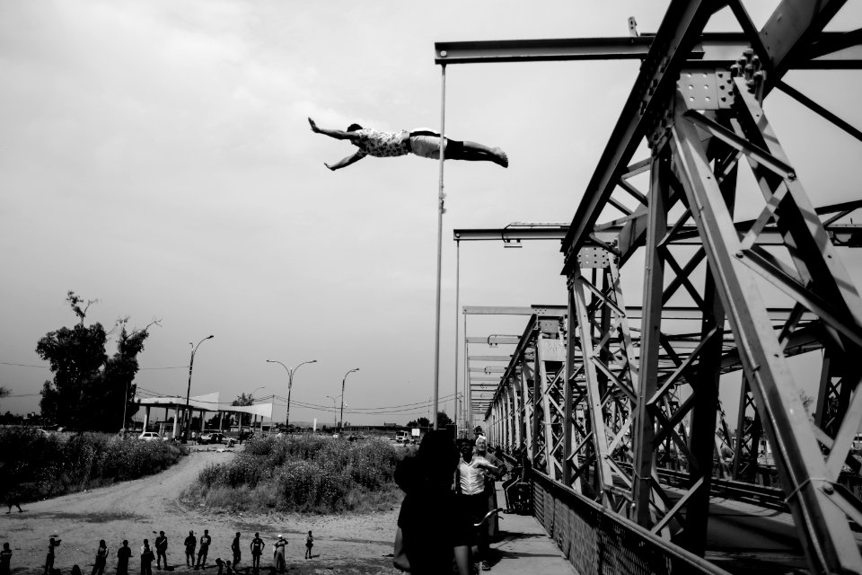 Young men gathered at Mosul's "Old Bridge" over the Tigris River in summer of 2019 to jump into the water and escape summer heat 18