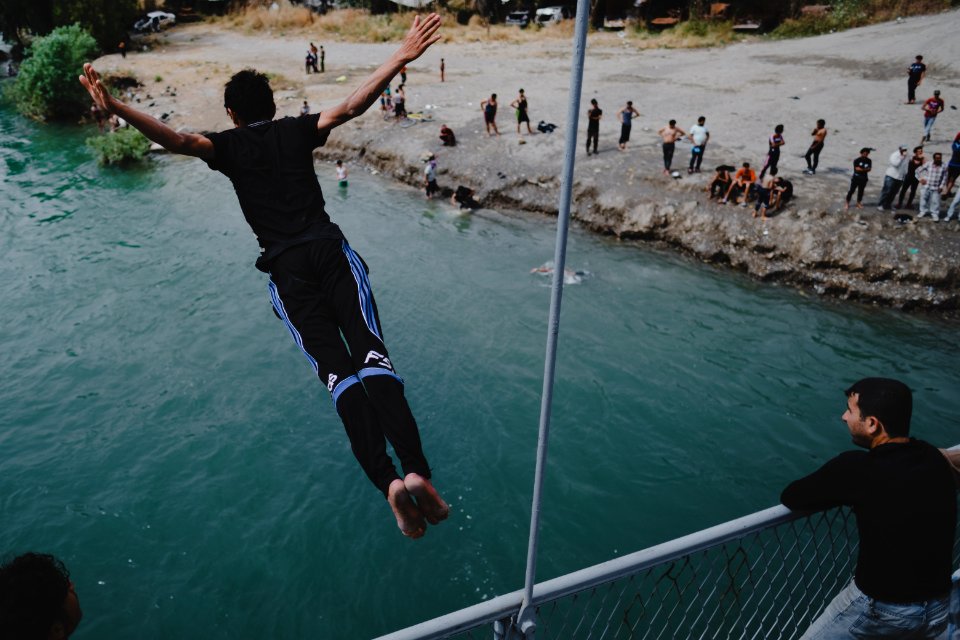 Young men gathered at Mosul's "Old Bridge" over the Tigris River in summer of 2019 to jump into the water and escape summer heat 12
