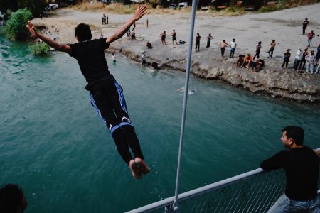 Young men gathered at Mosul's "Old Bridge" over the Tigris River in summer of 2019 to jump into the water and escape summer heat 12