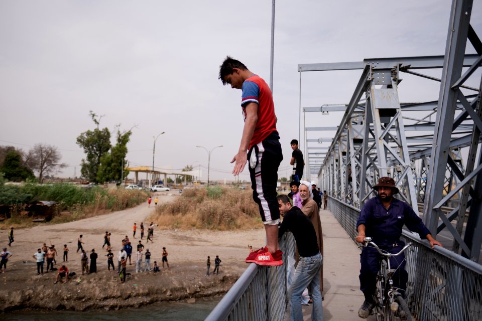 Young men gathered at Mosul's "Old Bridge" over the Tigris River in summer of 2019 to jump into the water and escape summer heat 01