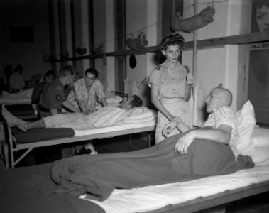 Ziekenzaal Een verpleegster van Vrouwenkorps KNIL meet de polsslag van een pati, Bestanddeelnr 10762