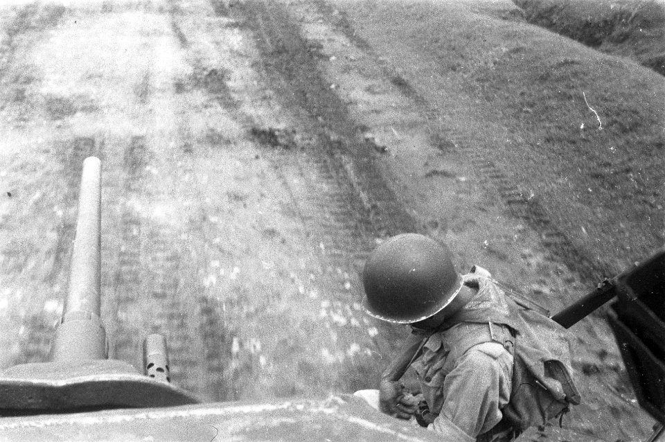 Zicht vanuit de toren van de tank op de kanonsloop. Rechts zit een gehelmde mili, Bestanddeelnr 285