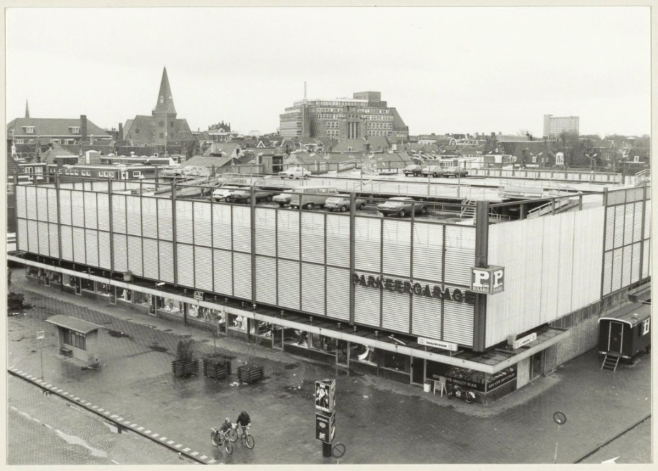 Zicht over de Raaks naar het zuidoosten, op de voorgrond de parkeergarage met winkels eronder. NL-HlmNHA 54010171