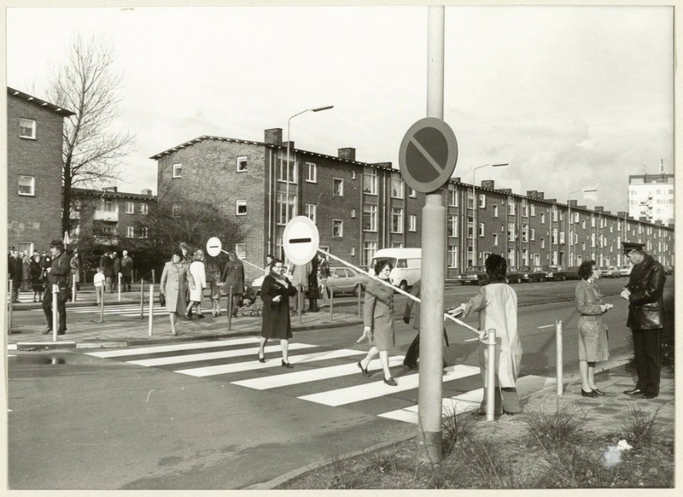 Zebrapad door moeders beveiligd met een Endlicharm ( slagboom). Op de Prins Bernhardlaan, hoek Prinses Beatrixplein. NL-HlmNHA 54003784