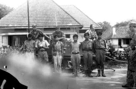 Zes krijgsgevangenen staan voor de zijkant van een bren-carrier. Op de carrier , Bestanddeelnr 7316