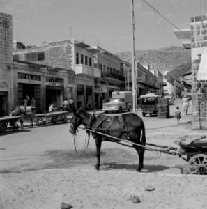 Winkels in Tiberias met daarboven woningen met balkons. Op de rijweg autoverkeer, Bestanddeelnr 255-4087