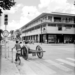 Winkelpand in Paramaribo met onder andere een fotowinkel en een rijwielenhandel., Bestanddeelnr 252-4944
