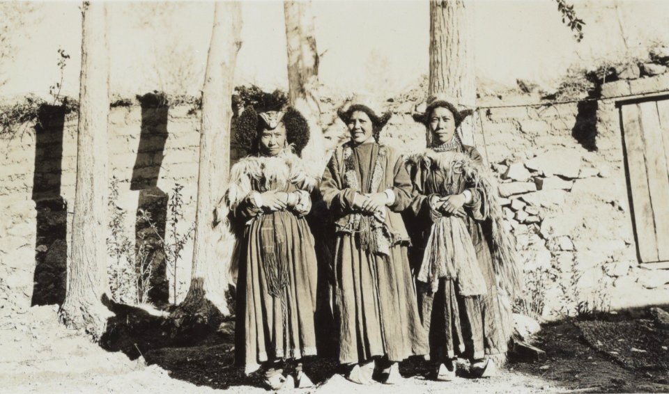 Women of Ladakh in Leh on 23 May 1929-05-23, from- Albumblad met 3 fotos. Linksboven het expeditiegezelschap voor het huis van Kh, Bestanddeelnr 32 062 (cropped)