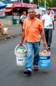 Working old man carrying buckets