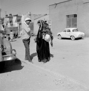 Bedoeïenenvrouw in traditionele kledij in gesprek met een man op straat zij dra, Bestanddeelnr 255-3447 photo