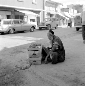 Bejaarde man met handelswaar in banenendozen langs de kant van de weg, Bestanddeelnr 255-3529 photo