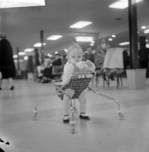 Amerikaanse baby in loopstoel op Schiphol, Bestanddeelnr 913-3265