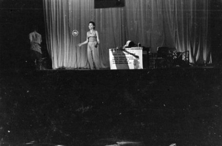 Cabaret voorstelling. Een man zit gebogen over een tafel. Een vrouw staat bij e…, Bestanddeelnr 6178