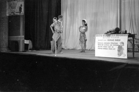 Cabaret voorstelling. Een man zit gebogen over een tafel. Een andere staat bij m, Bestanddeelnr 6180