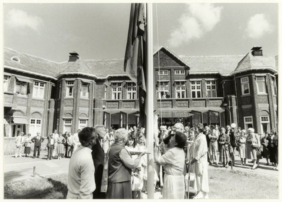 Burgemeester Schmitz hijst de vlag op het terrein van het verzorgingstehuis Spaar en Hout na de renovatie
