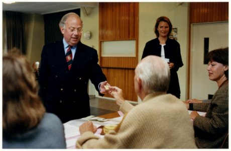 Burgemeester Van der Heijden en zijn vrouw brengen hun stem uit bij het stembureau in de Calvijnzaal. NL-HlmNHA 54037318