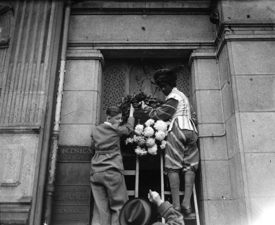 Zwarte Piet hangt kruis aan de gevel Huize de Bisschop, Bestanddeelnr 902-4833