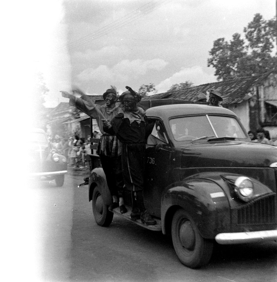 Zwarte Pieten op de treeplank van een pick-up truck tijdens intocht Sint Nicolaa, Bestanddeelnr 12608