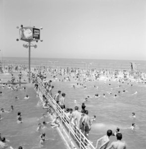 Zwemmende en spelende badgasten in het water van een openlucht zwembad, Bestanddeelnr 255-1953