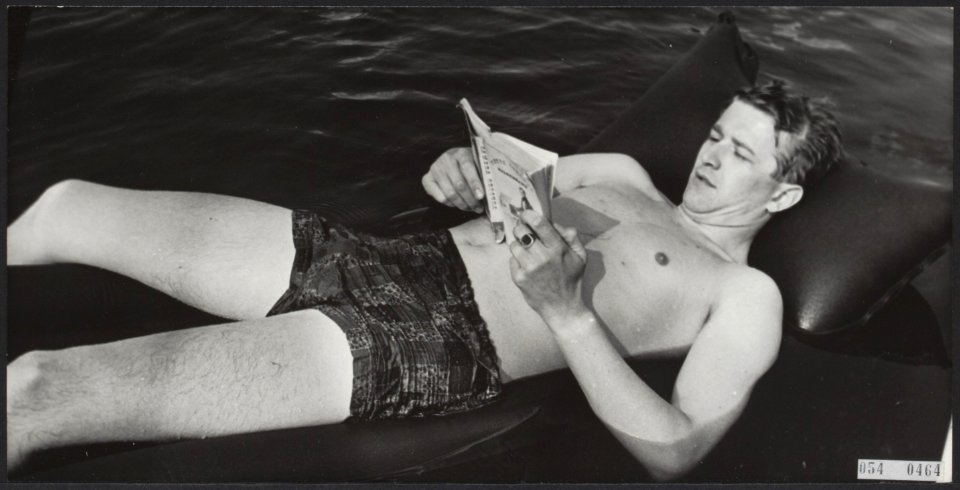 Zomer. Man leest een boek liggend op een opblaasbed, Bestanddeelnr 054-0464