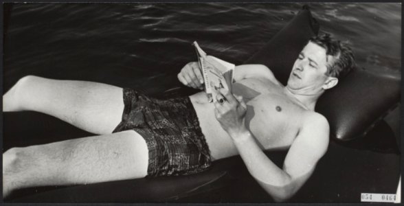 Zomer. Man leest een boek liggend op een opblaasbed, Bestanddeelnr 054-0464