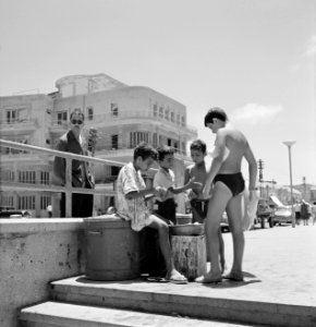 Zomers geklede kinderen eten vruchten aan de rand van de straat die naar het str, Bestanddeelnr 255-1939
