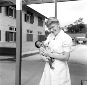 Zuster Agaat met een boslandcreoolbaby in het hospitaal 'Prinses Juliana' in Kab, Bestanddeelnr 252-6025
