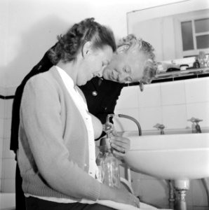 Zuster M.G. Niemeyer assisteert mevrouw Rietveld bij het kolven met behulp van d, Bestanddeelnr 254-2489