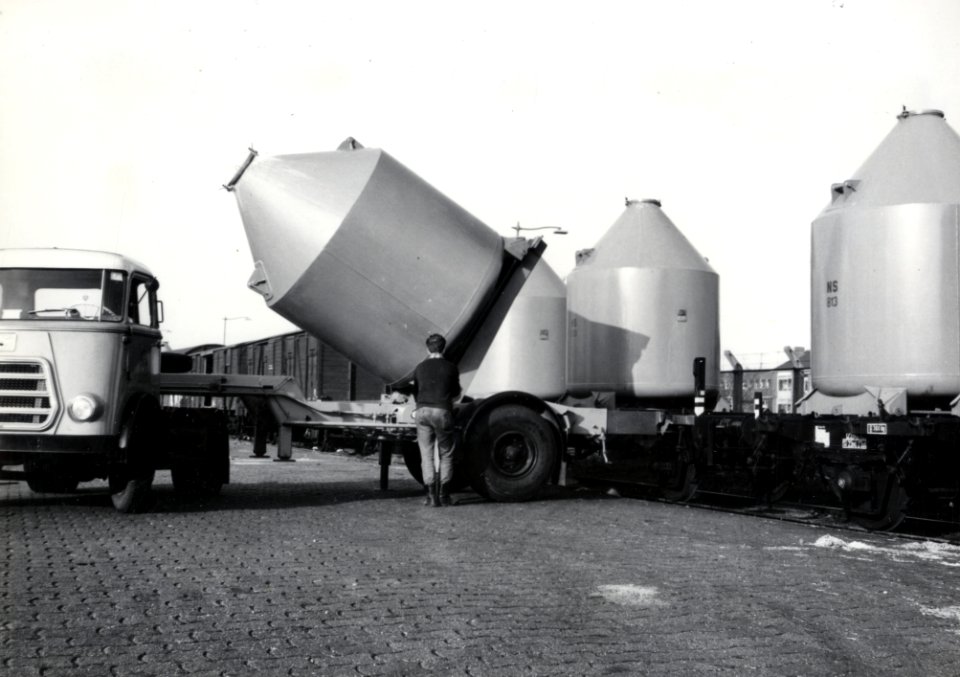 HUA-169595-Afbeelding van het overladen van een silolaadkist voor het vervoer van soda van trein naar vrachtwagen op de laad- en losplaats van het N.S.-station Schiedam
