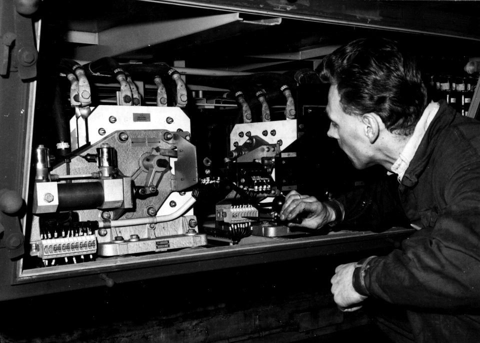 HUA-159385-Afbeelding van een onderhoudsmonteur tijdens werkzaamheden aan de electrische installatie van een electrisch treinstel plan T mat 1964 van de NS in de