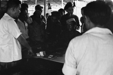 Indonesische burgers en militairen spelen een bordspel en zetten geld in, Bestanddeelnr 2288
