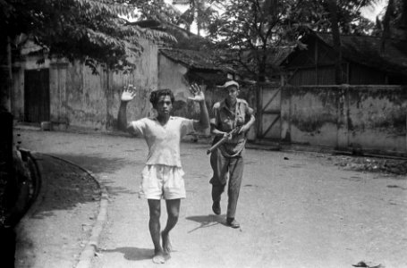 Indonesische jonge man met de handen omhoog wordt onder schot gehouden en afgevo, Bestanddeelnr 5723