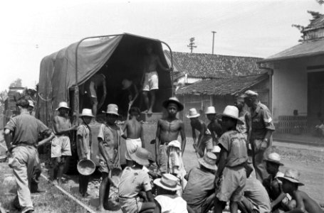 Indonesische jongens werken als koelies aan wegherstel Achter hen een militaire, Bestanddeelnr 6615