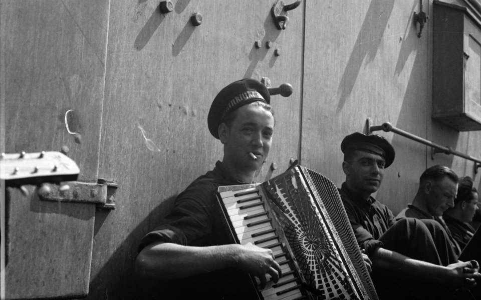 Hr. Ms. Flores. Bemanningslid speelt accordeon tijdens een pauze, Bestanddeelnr 934-9994
