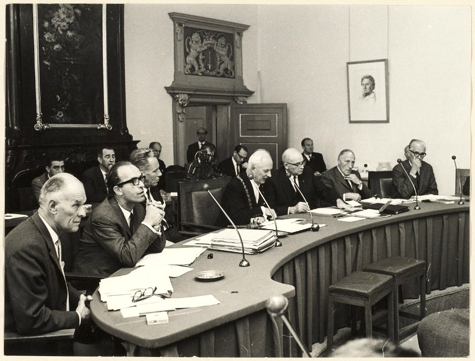 Het college van burgemeester en wethouders tijdens een gemeenteraadsvergadering, ±1965. NL-HlmNHA 54003681