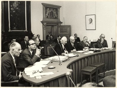 Het college van burgemeester en wethouders tijdens een gemeenteraadsvergadering, ±1965. NL-HlmNHA 54003681