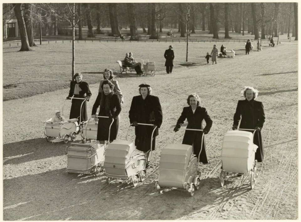 Jonge moeders achter hun kinderwagen genieten van de zon tijdens een wandeling op de DreefHaarlemmerhout. NL-HlmNHA 54004497