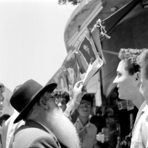 Joodse jongemannen en een oudere man staan voor een kiosk en voeren een gesprek , Bestanddeelnr 255-1847 photo